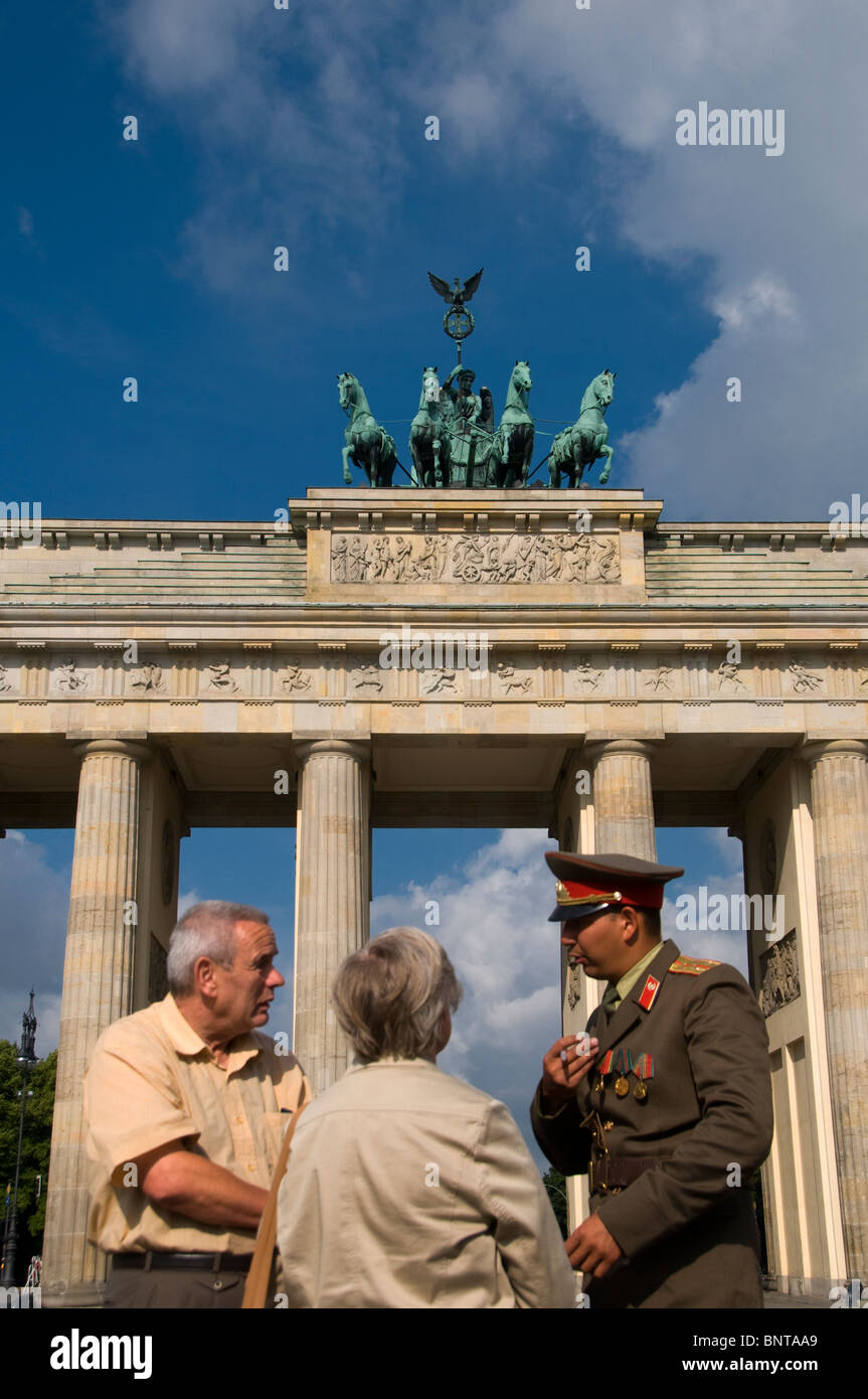 I turisti parlano di un attore vestito come ex soldato DDR a Brandenburger Tor, porta di Branderburg a Pariser Platz Berlino Germania Foto Stock