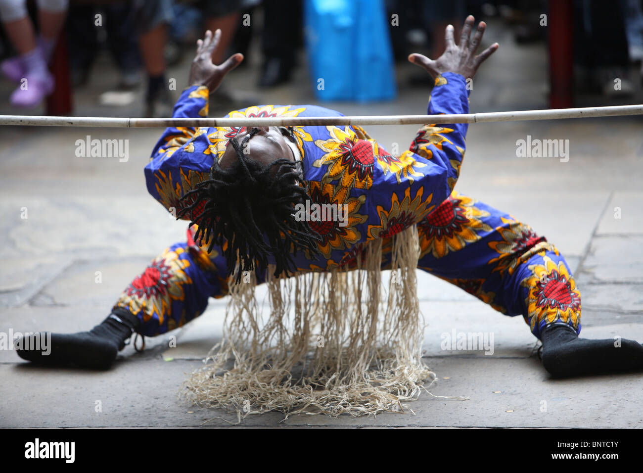 Un animatore di strada limbo dancing in Covent Garden Piazza, Londra, WC2. Foto Stock