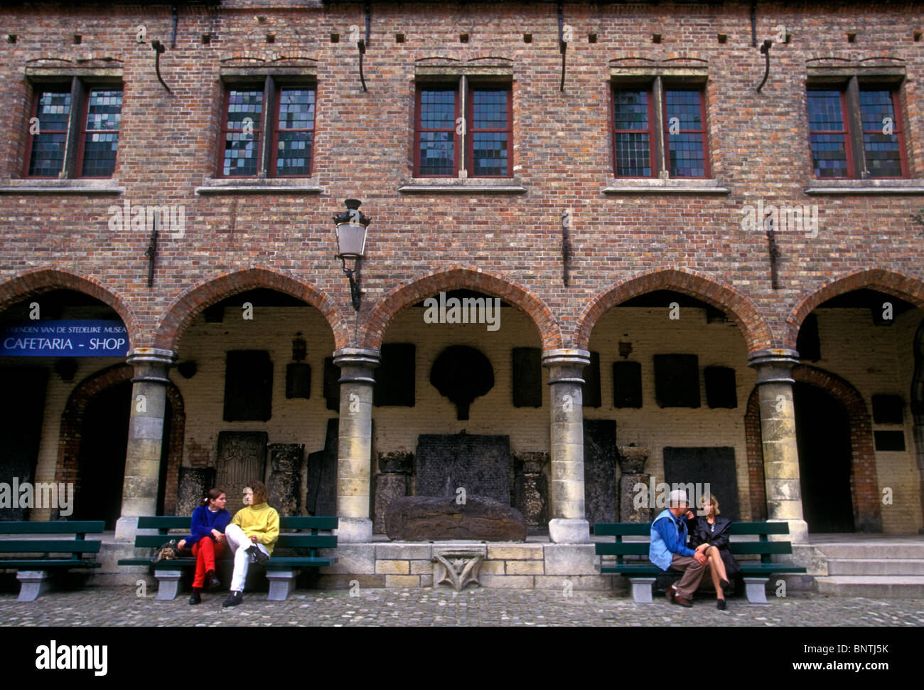 La Gente seduta sul banco di fronte al Museo Gruuthuse nella città di Brugge Fiandre occidentale provincia Belgio Europa Foto Stock