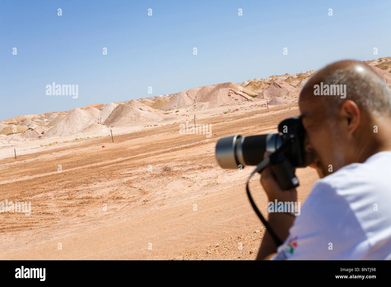 Un turista fotografie il paesaggio desertico di Coober Pedy opale. Coober Pedy, South Australia, Australia. Foto Stock