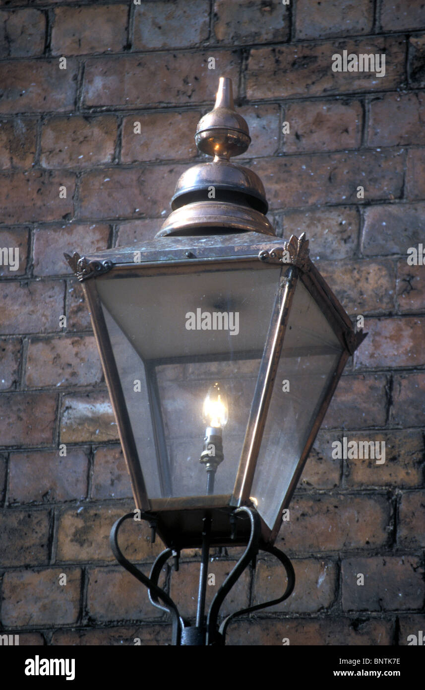 Luce artificiale - La vecchia moda via lampada assistita dal vecchio muro in mattoni emette il carattere e i ricordi dei tempi andati. Foto Stock