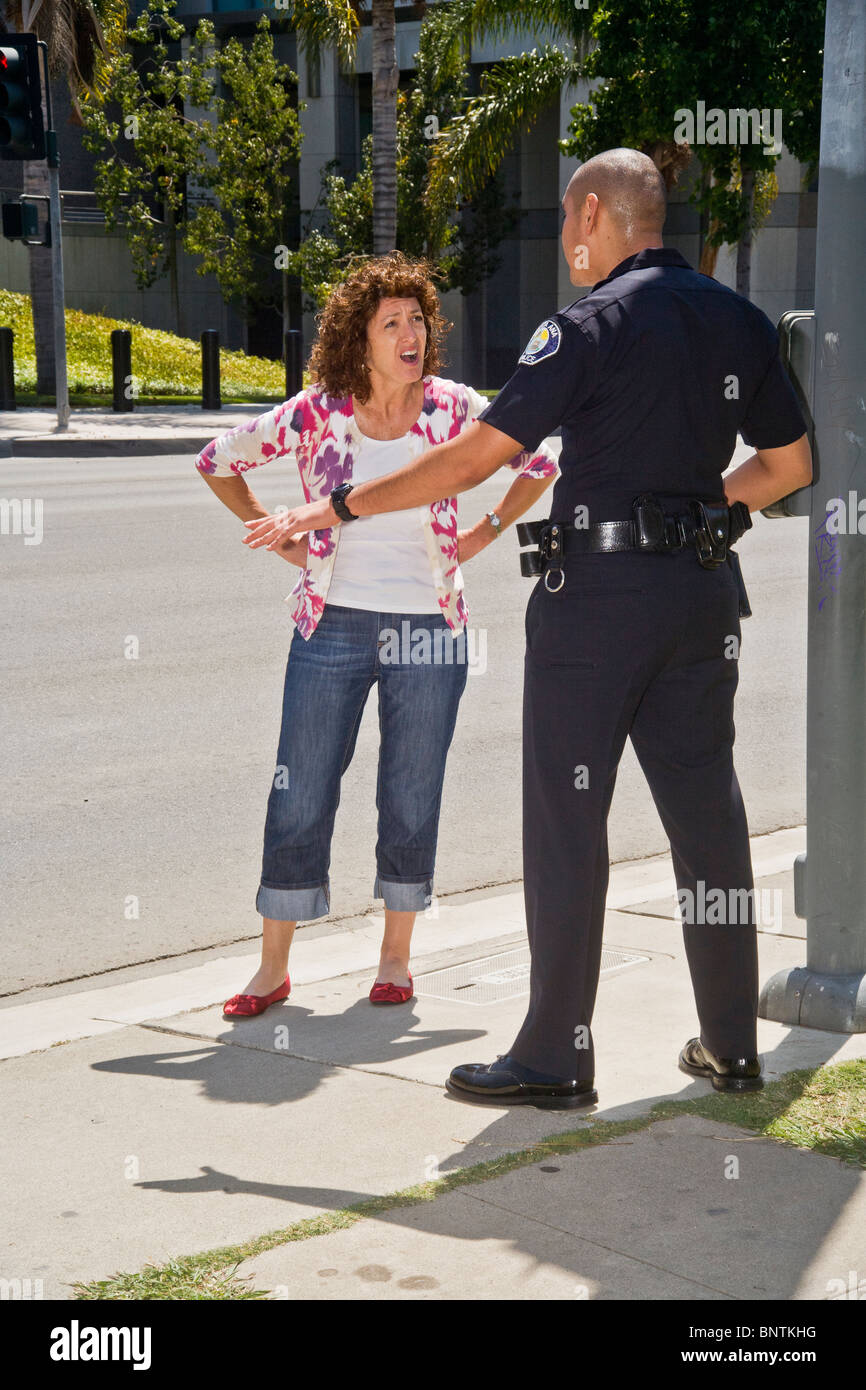 Una donna sostiene con un ispanico funzionario di polizia dopo essere stato fermato per una violazione del codice della strada in Santa Ana CA. Foto Stock