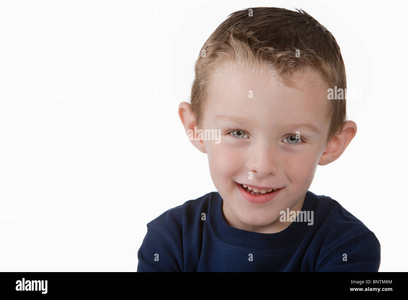 Giovane ragazzo in maglietta blu sorridente alla fotocamera Foto Stock