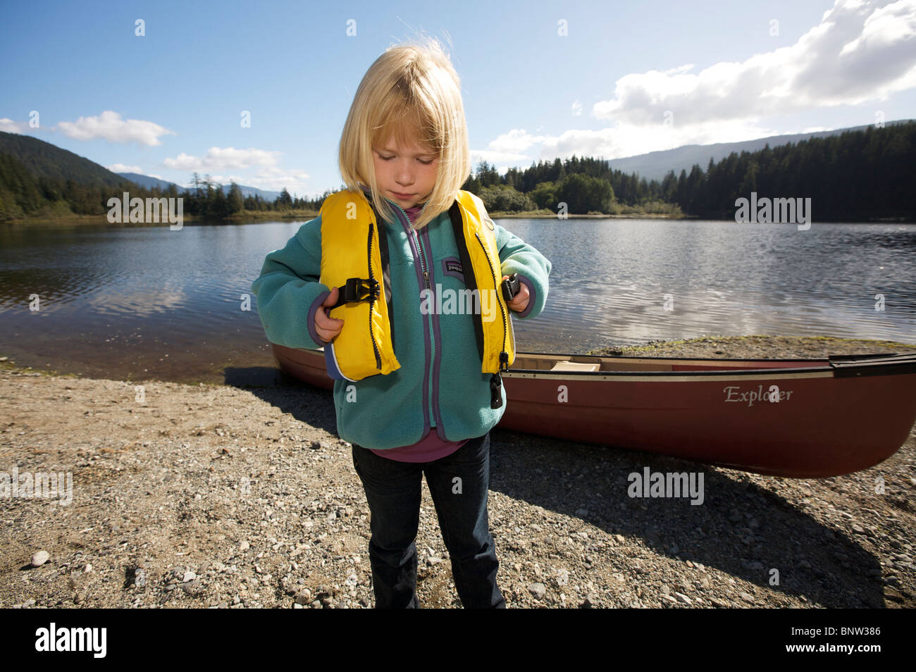 Una giovane ragazza mette su un giubbotto di sicurezza prima di canoa sul lago Foto Stock