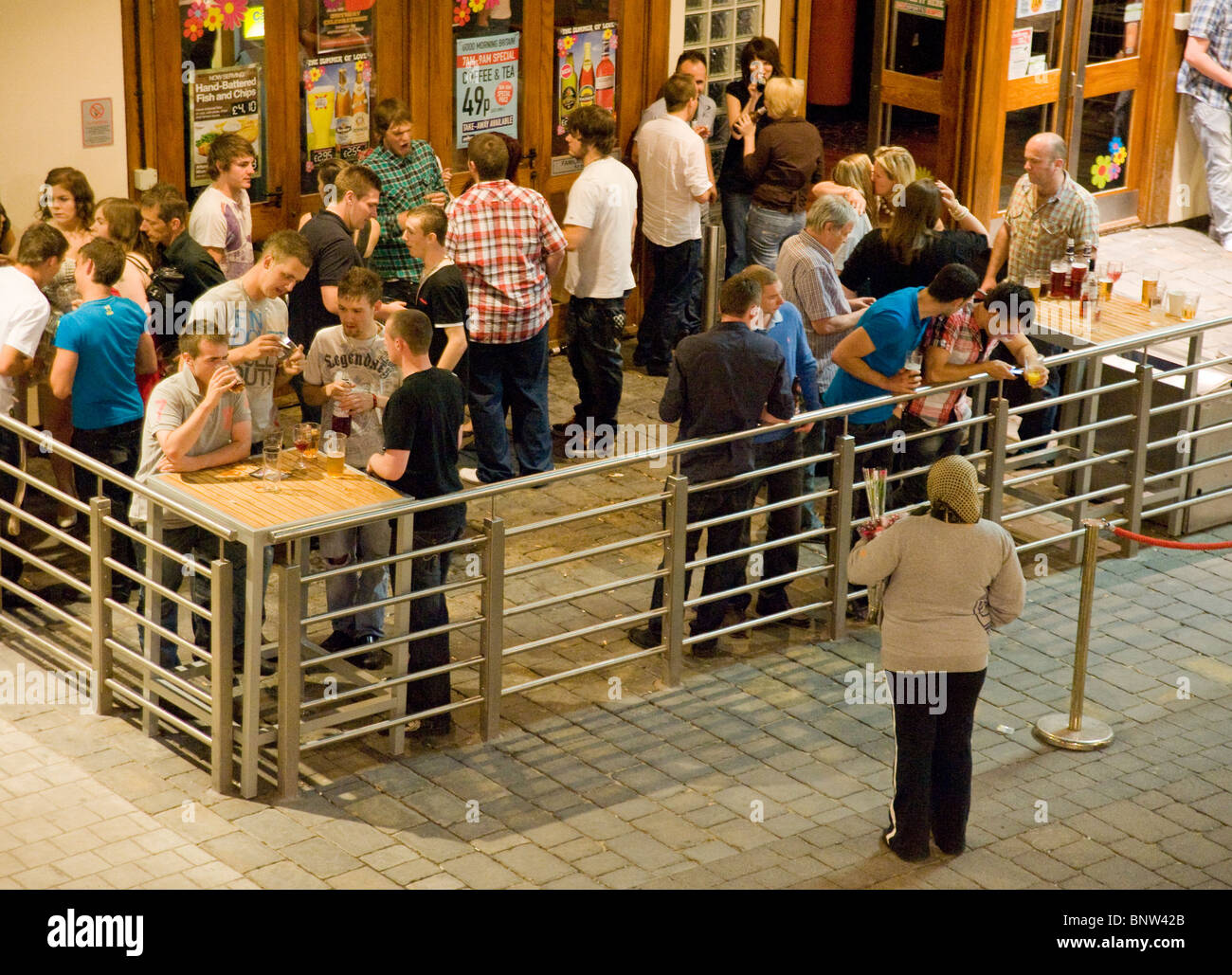 Persone di bere al di fuori di un bar Wetherspoon in Gran Bretagna Foto Stock