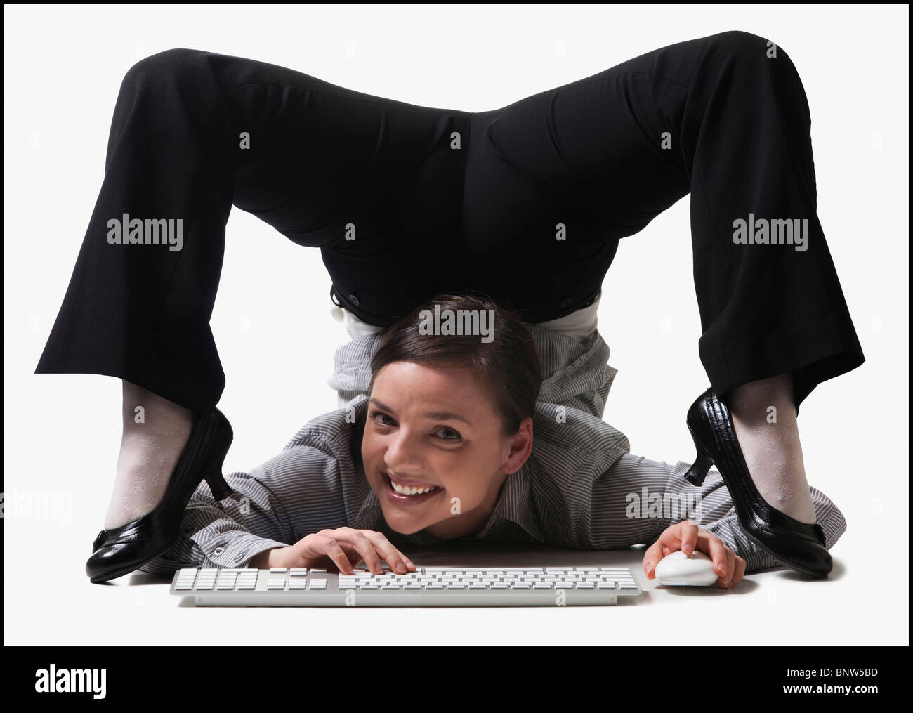 Imprenditrice contorting il suo corpo durante la digitazione Foto Stock
