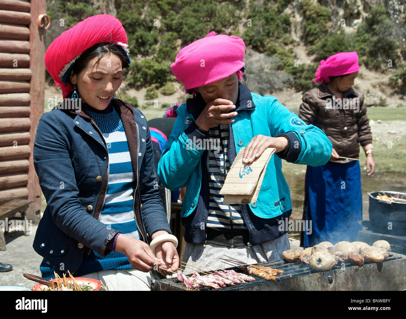 Le tre ragazze barbequeing shish kebab Yunnan in Cina Foto Stock