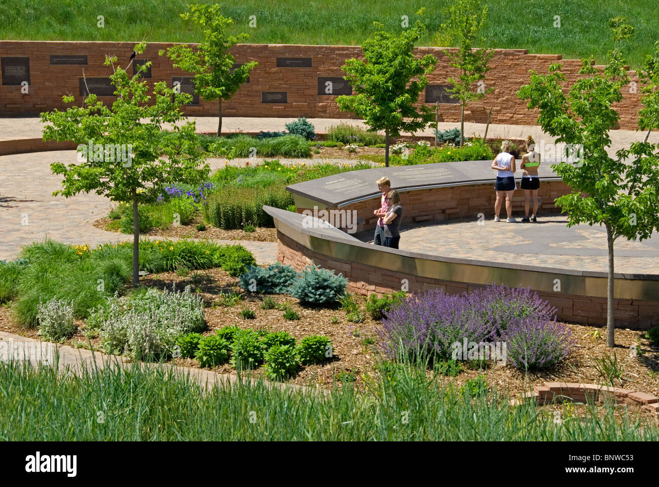I visitatori della bella Columbine High School Memorial leggere placche, Littleton Colorado noi in giugno. Più le placche su parete distanti. Foto Stock