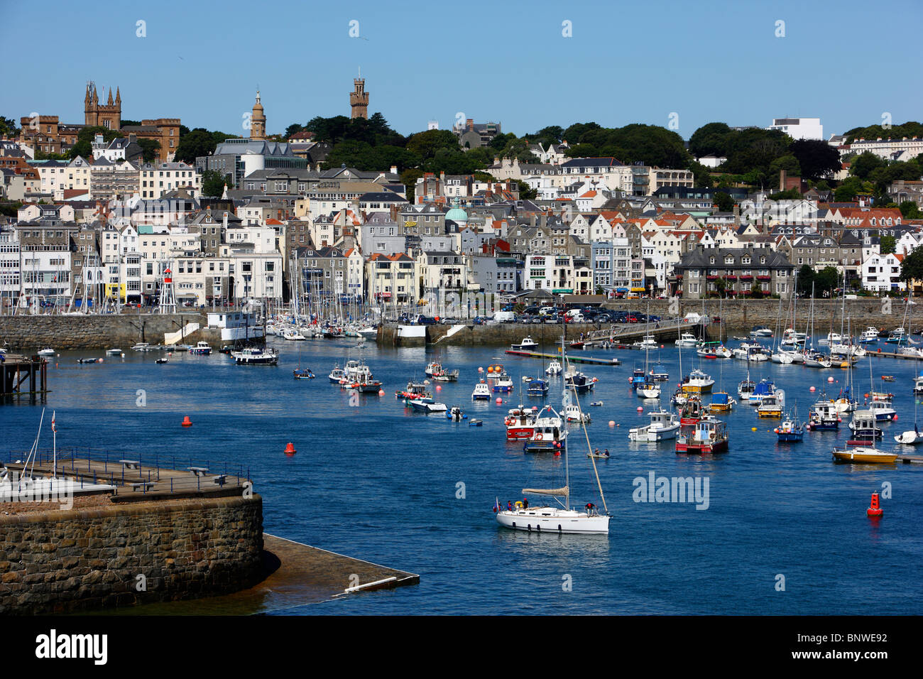 Porto Porto di St Peter Port Guernsey, Regno Unito, nelle Isole del Canale. Barche a vela e yacht nel bacino portuale, skyline della città Foto Stock