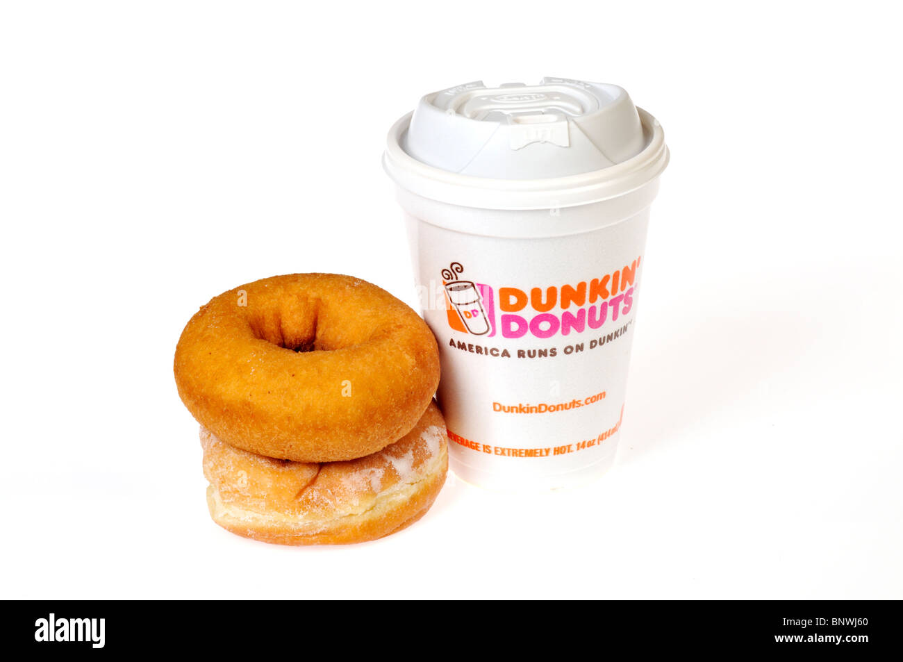 Una calda tazza di polistirolo di Dunkin Donuts caffè con la pianura e la jelly -riempito le ciambelle impilati su uno sfondo bianco. Tagliare Foto Stock