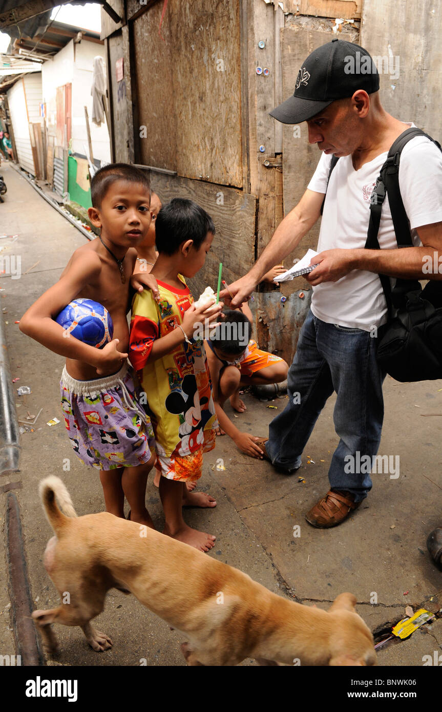 I bambini con il fotografo , Klong Toey slum , bangkok, Thailandia Foto Stock