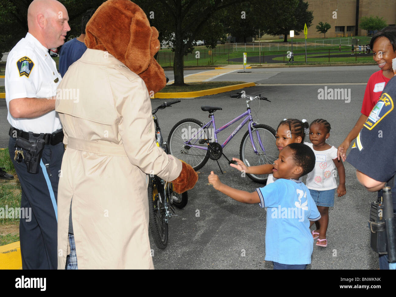 Il Greenbelt Md. USA i bambini salutare McGruff il cane del crimine e delle forze di polizia al ventisettesimo annuale National Night Out Foto Stock