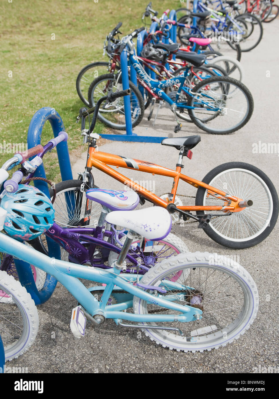 Fila di biciclette da bambino rinchiuso nel cortile della scuola Foto Stock