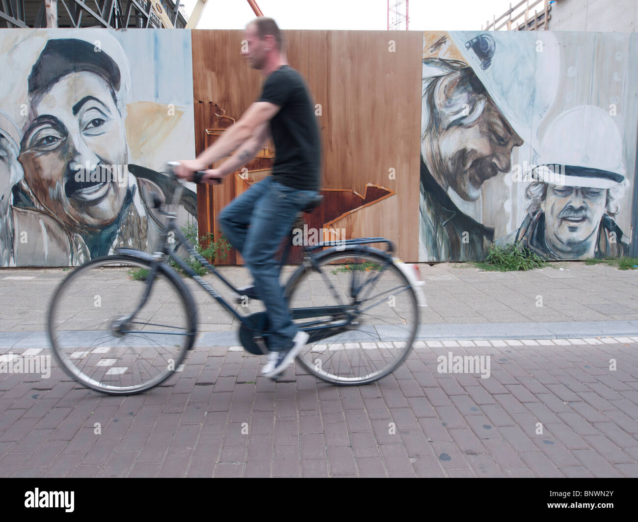I ciclisti in sella ultimi dipinti sulla parete accanto al cantiere per il nuovo Museo Stedelijk di Amsterdam Paesi Bassi Foto Stock