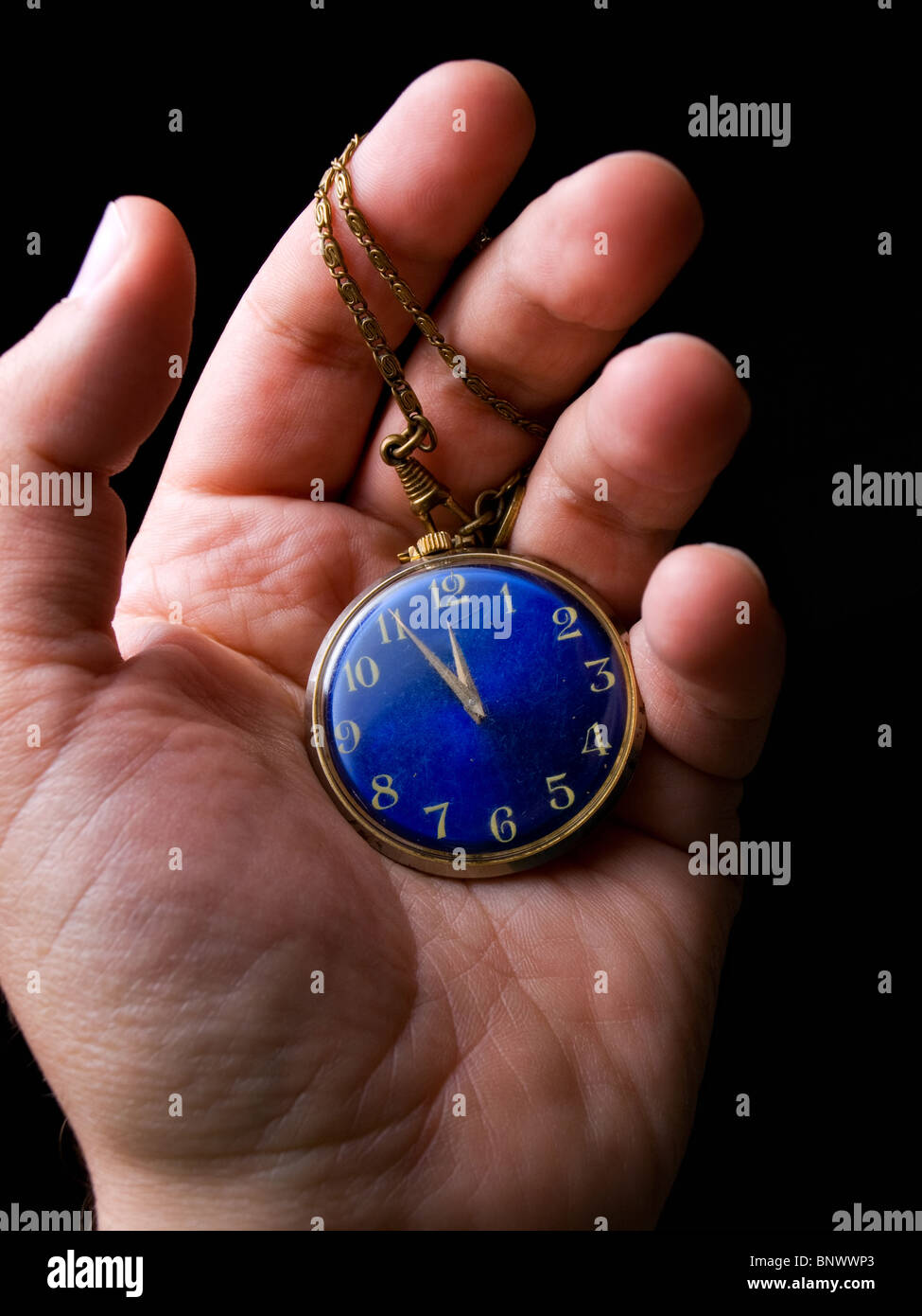 Il vecchio orologio da tasca in mano su uno sfondo nero Foto Stock