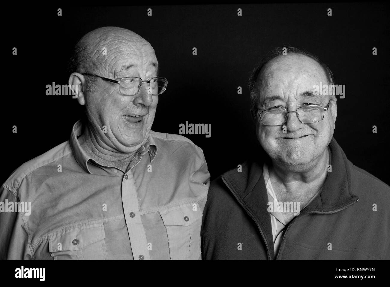 2 old pals avente una risata, in una chiave di basso ritratto in bianco e nero. Foto Stock