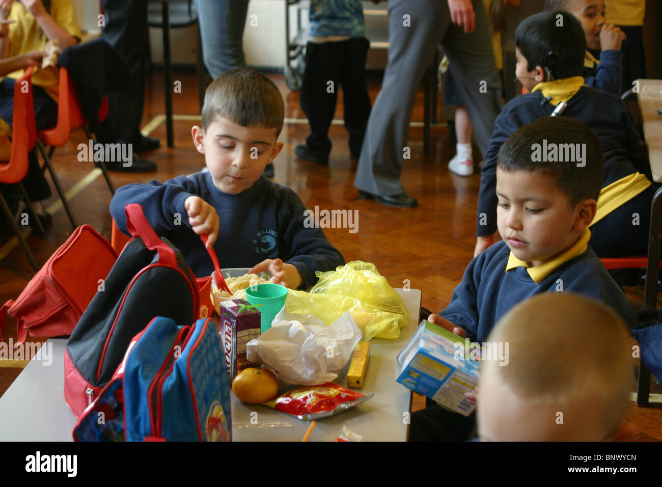 I bambini della scuola elementare di mangiare i loro pranzi in box Foto Stock