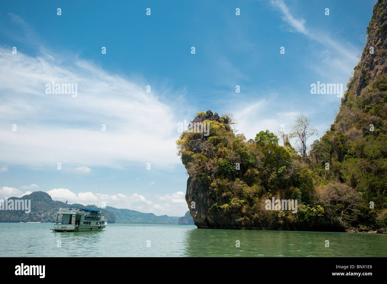 Imbarcazione turistica tra le insolite calcare o carso, isole nella Baia di Phang Nga, Thailandia Foto Stock