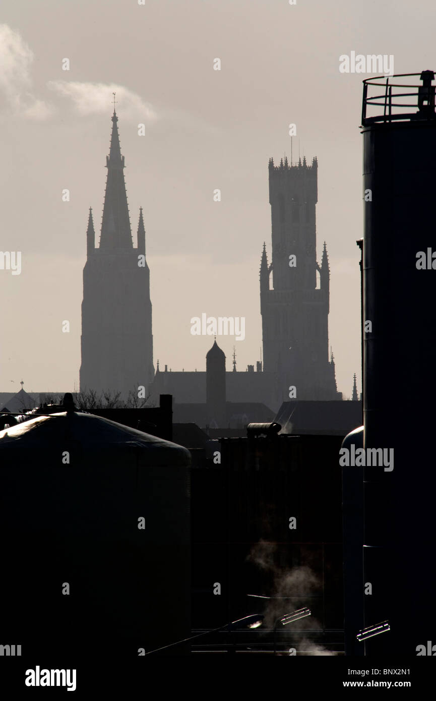 Una vista delle torri di Bruges in Belgio vista da un angolo non spesso utilizzato, con una tenuta industriale in primo piano Foto Stock Una vista delle torri di Bruges in Belgio vista da un angolo non spesso utilizzato, con una tenuta industriale in primo piano Foto Stock