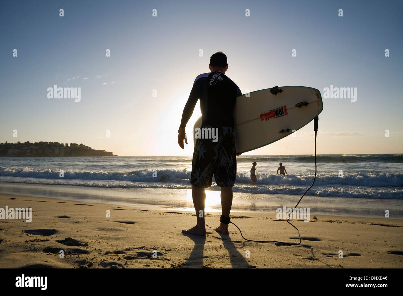 Un surfista si affaccia alle onde a Bondi Beach. Sydney, Nuovo Galles del Sud, Australia Foto Stock