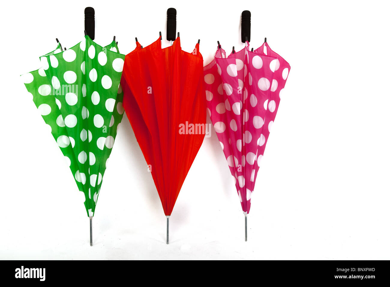 Tre colorati ombrelli ripiegato su un bianco sfondo isolato Foto Stock