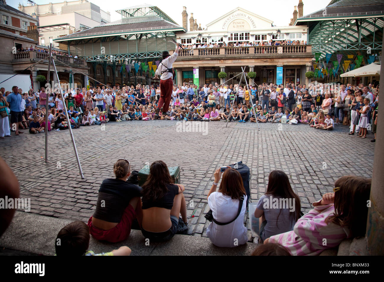 La folla a guardare la strada esecutori al Covent Garden di Londra, Inghilterra Foto Stock