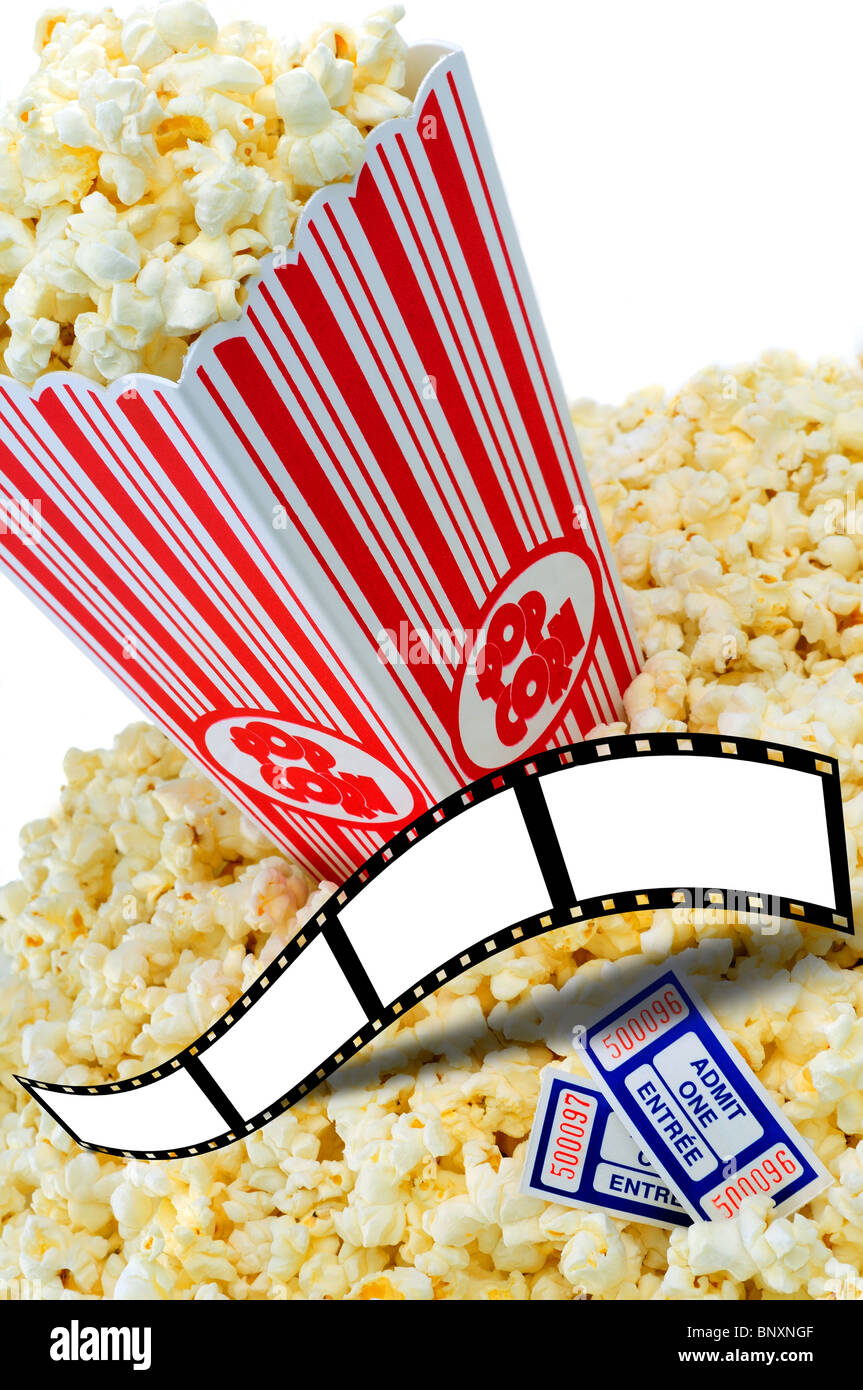 Grande contenitore Cinema Popcorn traboccante di popcorn fresco e biglietti di film Copia spazio per testo su film Filmstrip cornice verticale Foto Stock