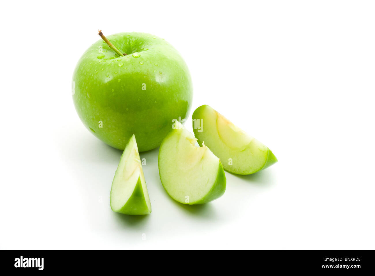 Verde mela con fettine su sfondo bianco Foto Stock
