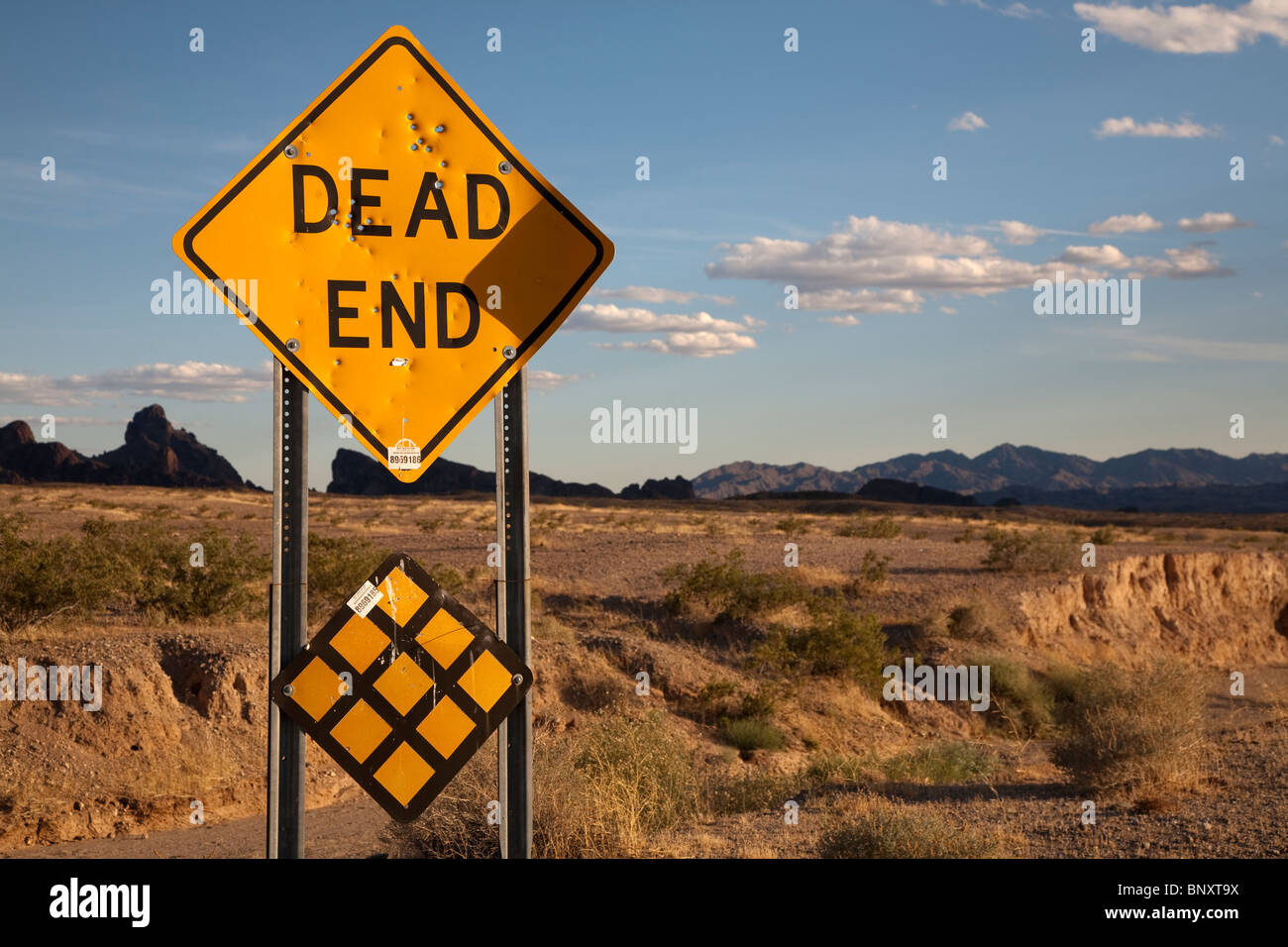 Dead End autostrada segno nel deserto in Arizona USA fucile con fori di proiettile danni Foto Stock