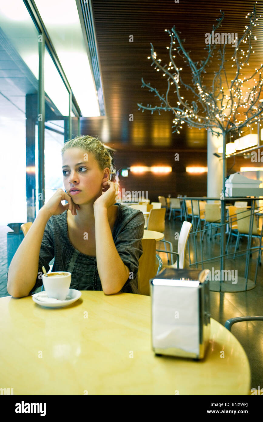Ragazza adolescente in cafe contemplatively guardando lontano Foto Stock