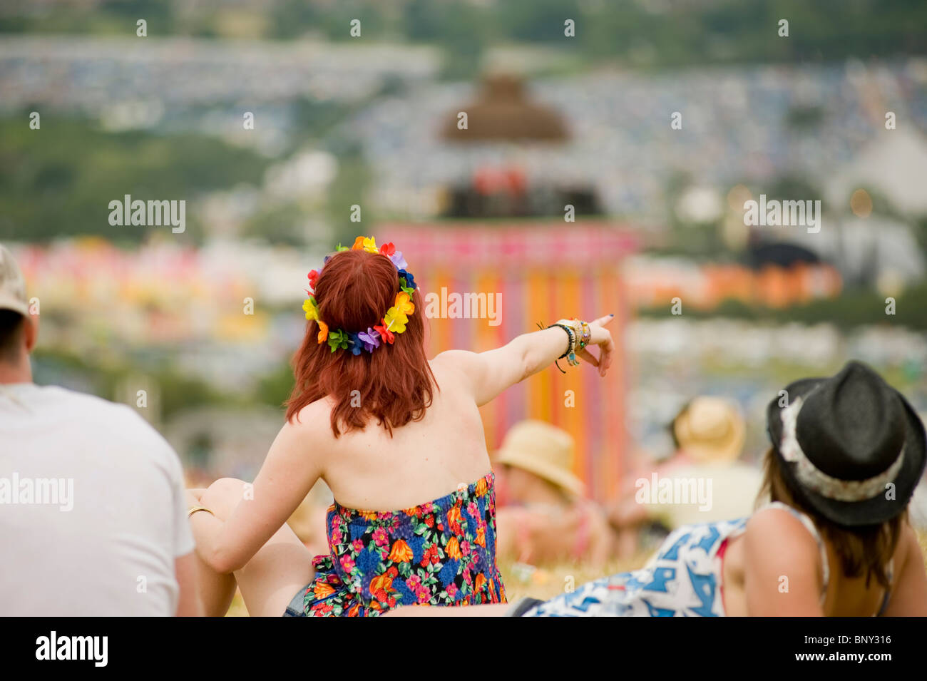 Glastonbury Festival - Inghilterra. Festival goer guarda sul festival da un alto punto panoramico vicino al parco. Foto Stock