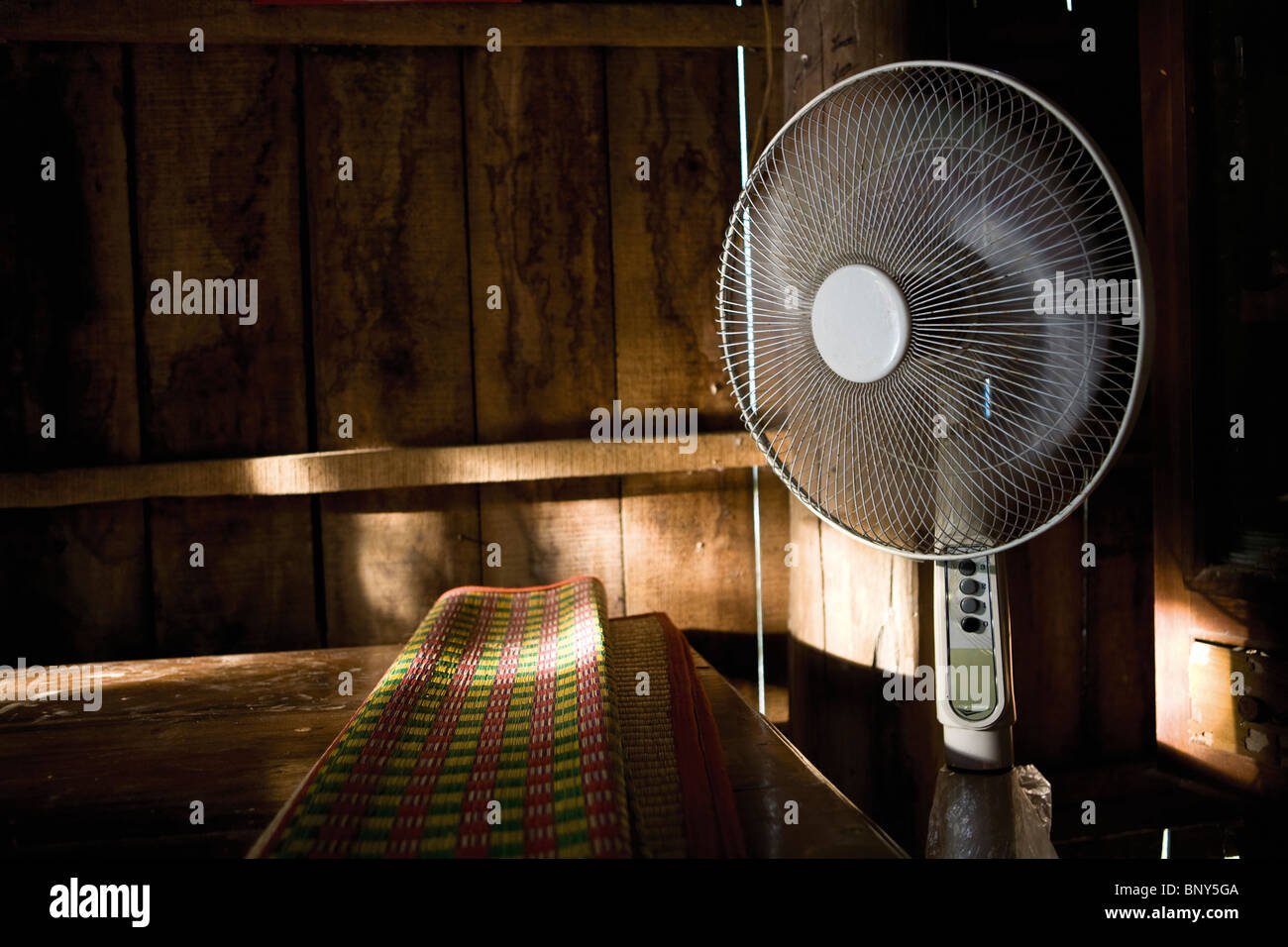Camera con letto mat sul letto in legno e ventilatori elettrici, Mangthit village, Vinh Long Provincia, Vietnam Foto Stock