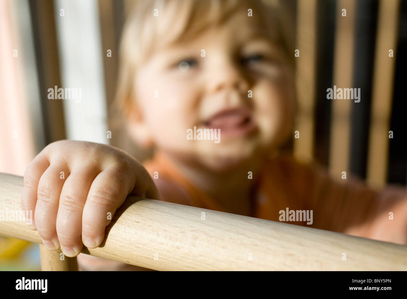 Bambino seduto nel presepe, messa a fuoco a portata di mano Foto Stock