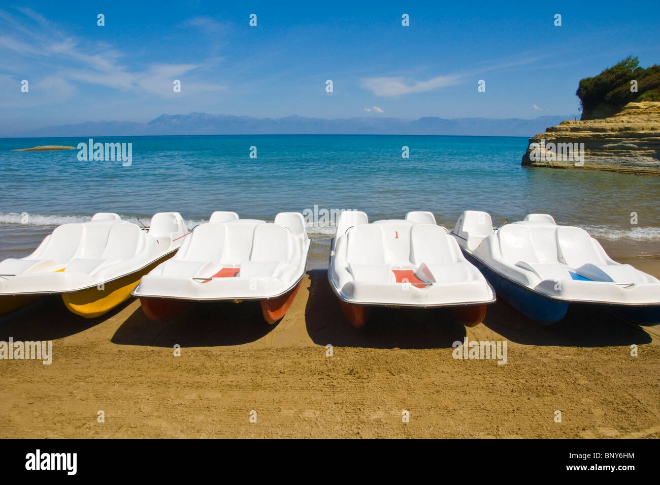 Spiaggia di Corfù. Le imbarcazioni turistiche sulla spiaggia a Sidari sull'isola greca di Corfu Grecia GR vista montagne albanesi sull orizzonte Foto Stock