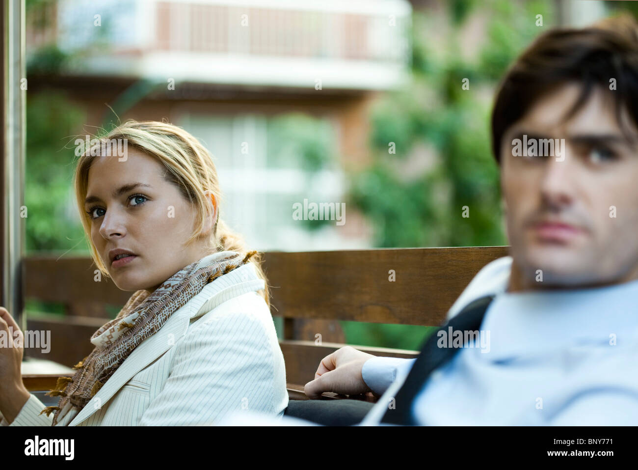 Giovane seduti all'aperto, donna che guarda lontano nella distrazione Foto Stock
