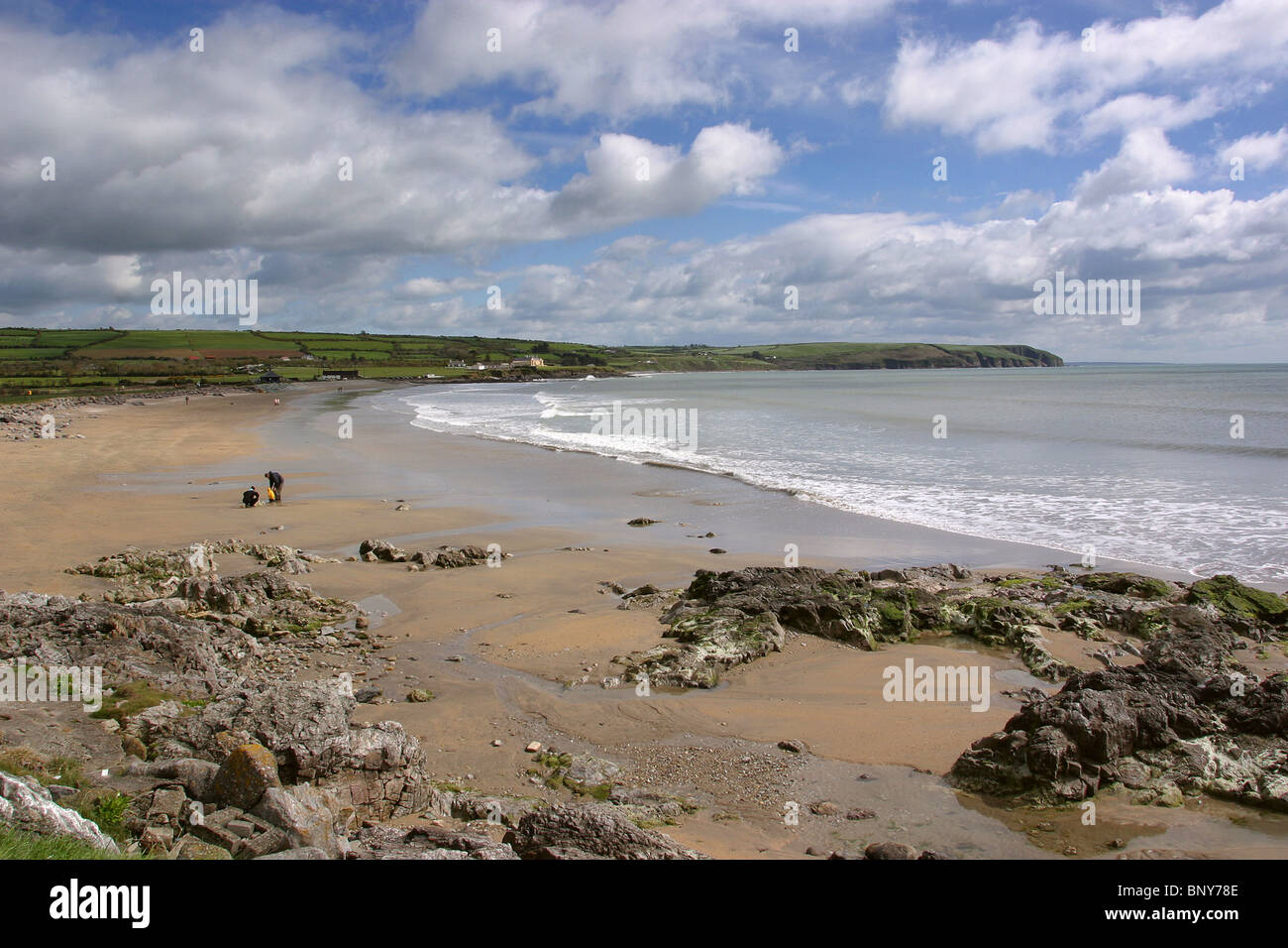 Irlanda, Waterford, Clonea, famiglia giocando sulla spiaggia vuota Foto Stock