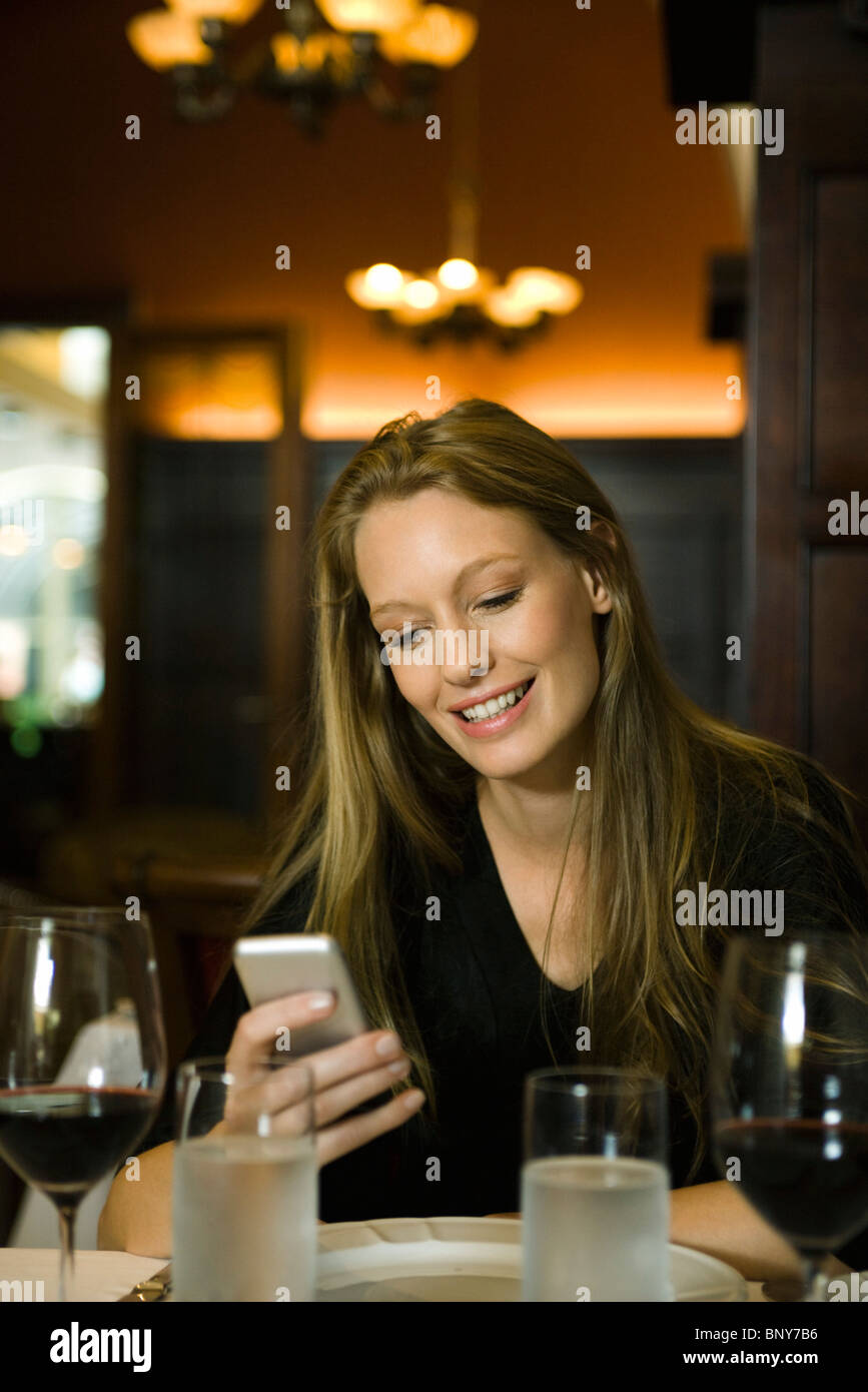 Donna di messaggistica di testo nel ristorante Foto Stock