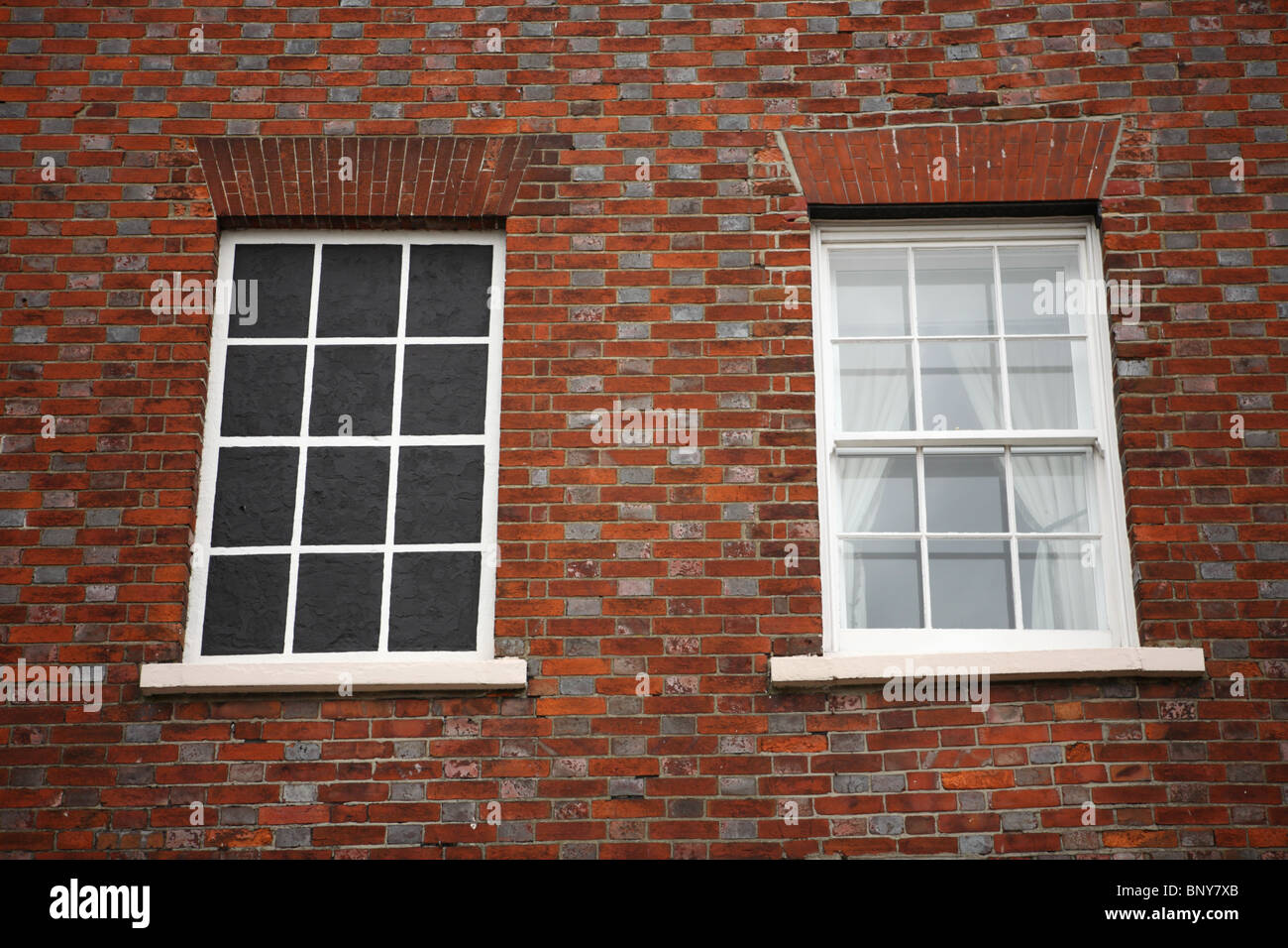 Parete edilizia con due finestre, una reale e una finta, in Petworth, Sussex , GU28. Foto Stock