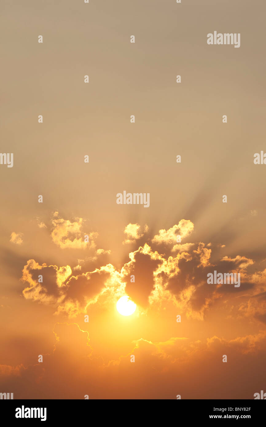 Sole nel cielo di nuvole al tramonto Foto Stock
