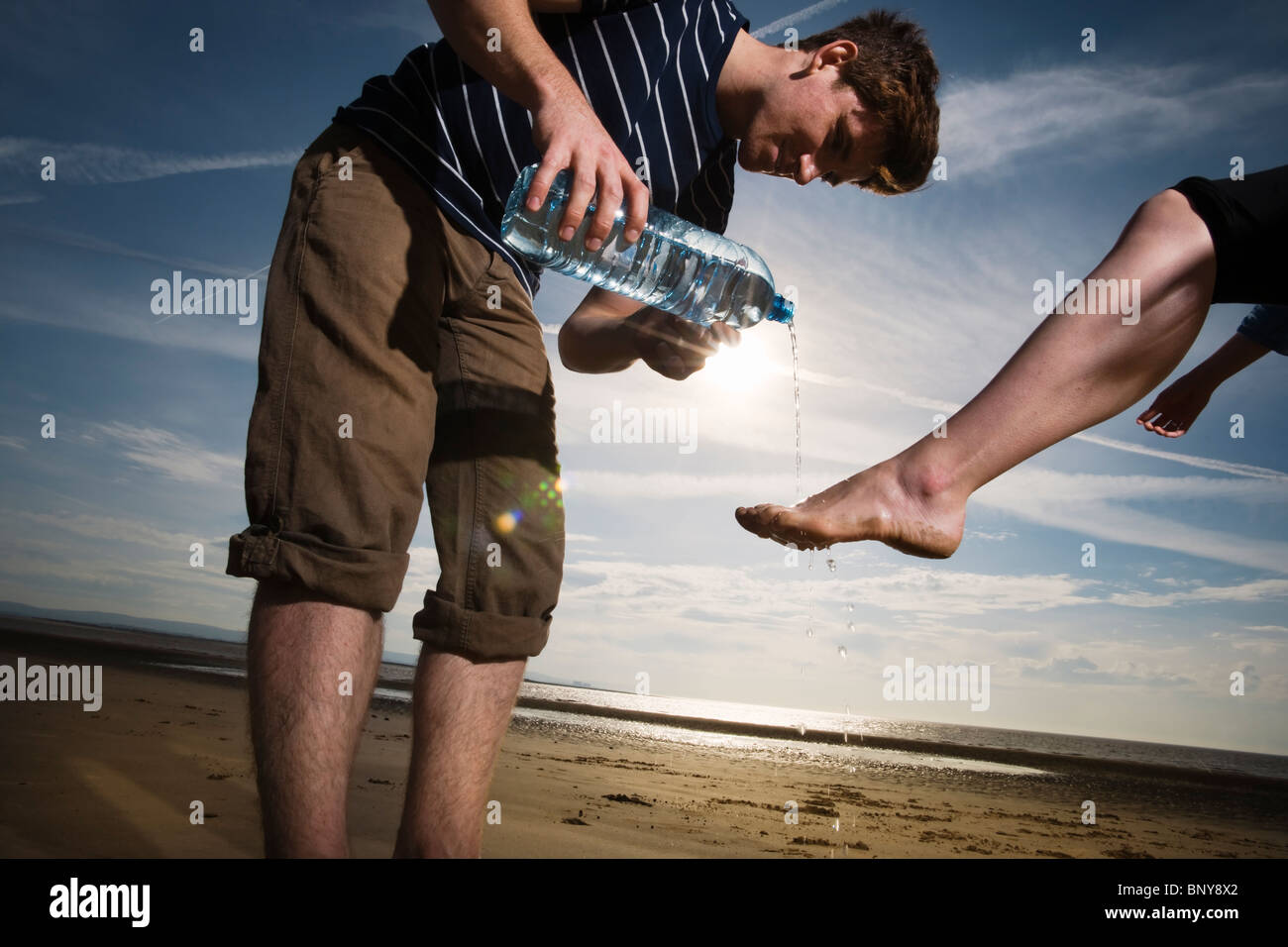 Uomo womans Lavaggio piedi sulla spiaggia Foto Stock