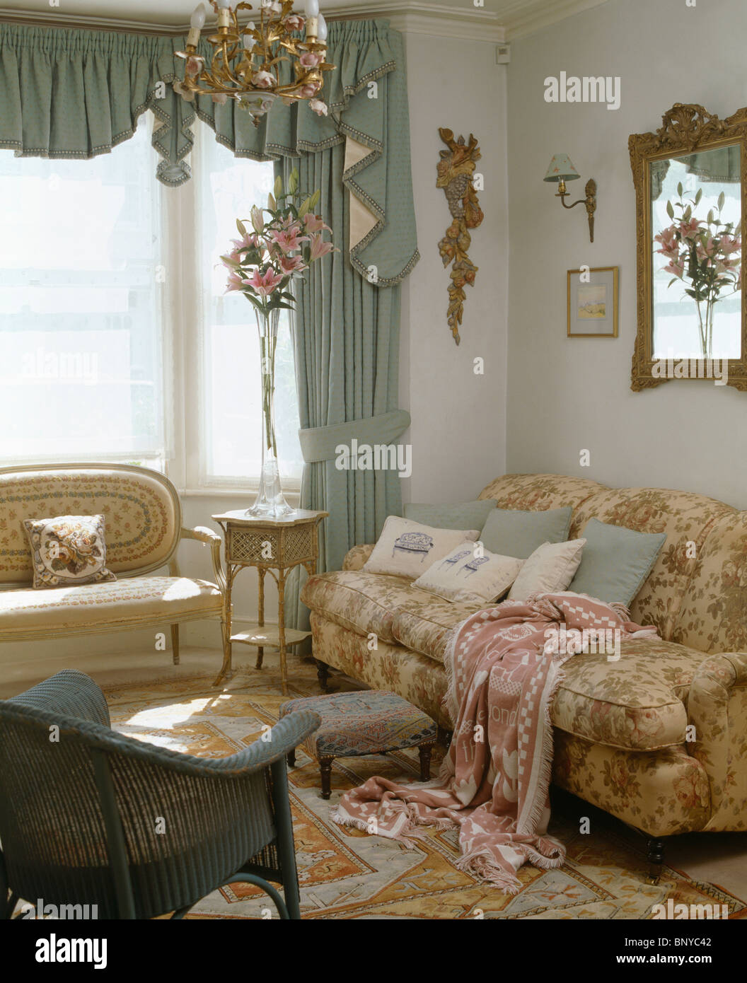 Verde pastello swagged tenda a finestra nel soggiorno con motivi buttare  sul divano confortevole Foto stock - Alamy