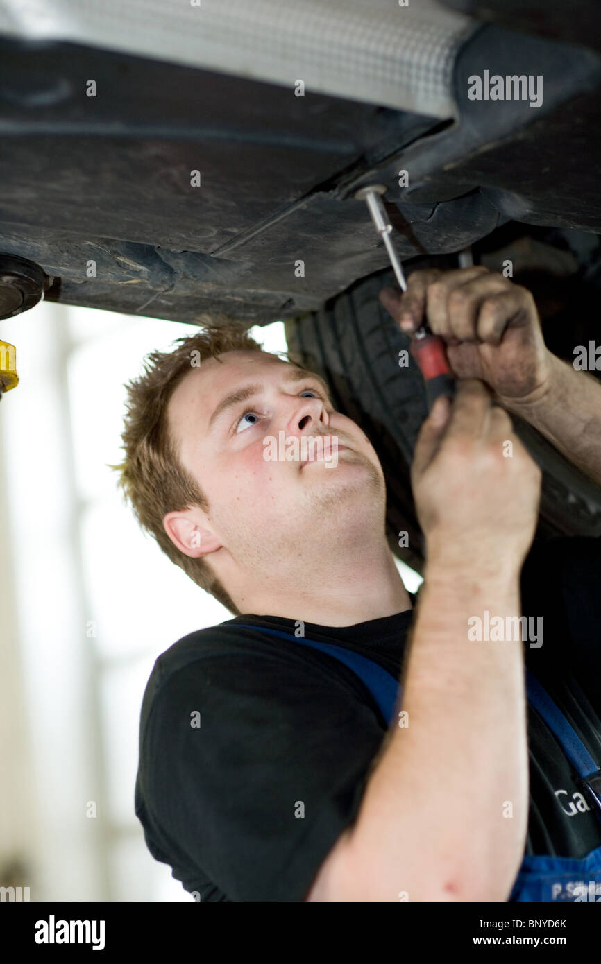 L'Assembler lavorando su di una vettura sulla piattaforma di sollevamento, Riedlingen, Germania Foto Stock