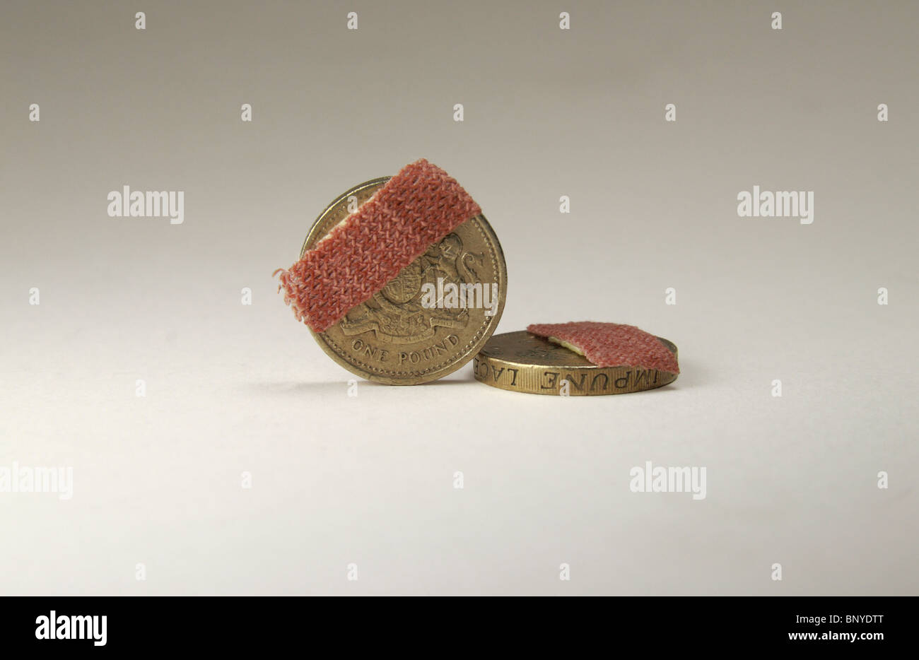 Due una libbra di monete con piccoli cerotti su uno sfondo bianco. Foto Stock