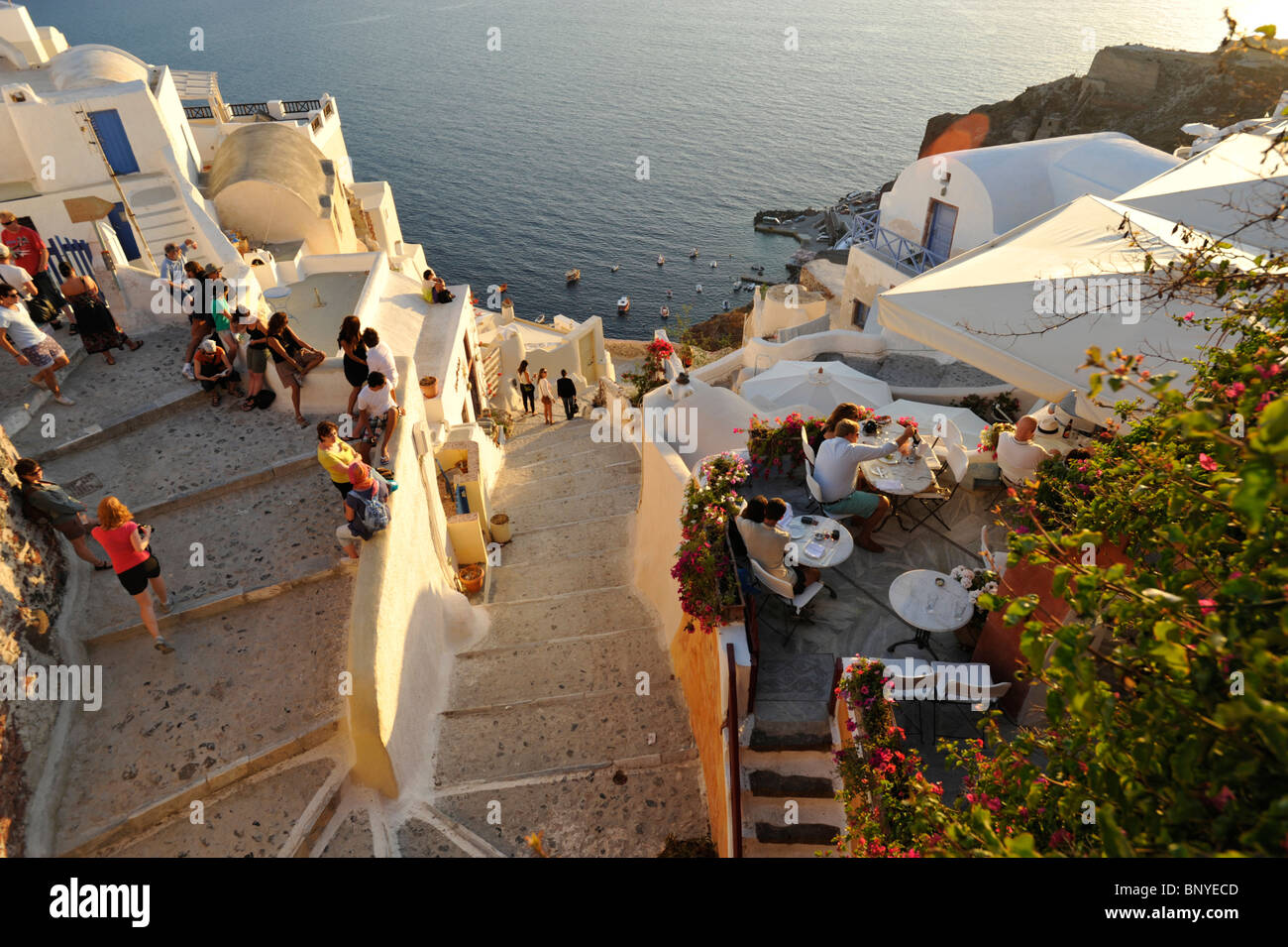 La folla di turisti si sono riuniti per vedere il tramonto a Oia sull'isola greca di Santorini nelle Cicladi Foto Stock