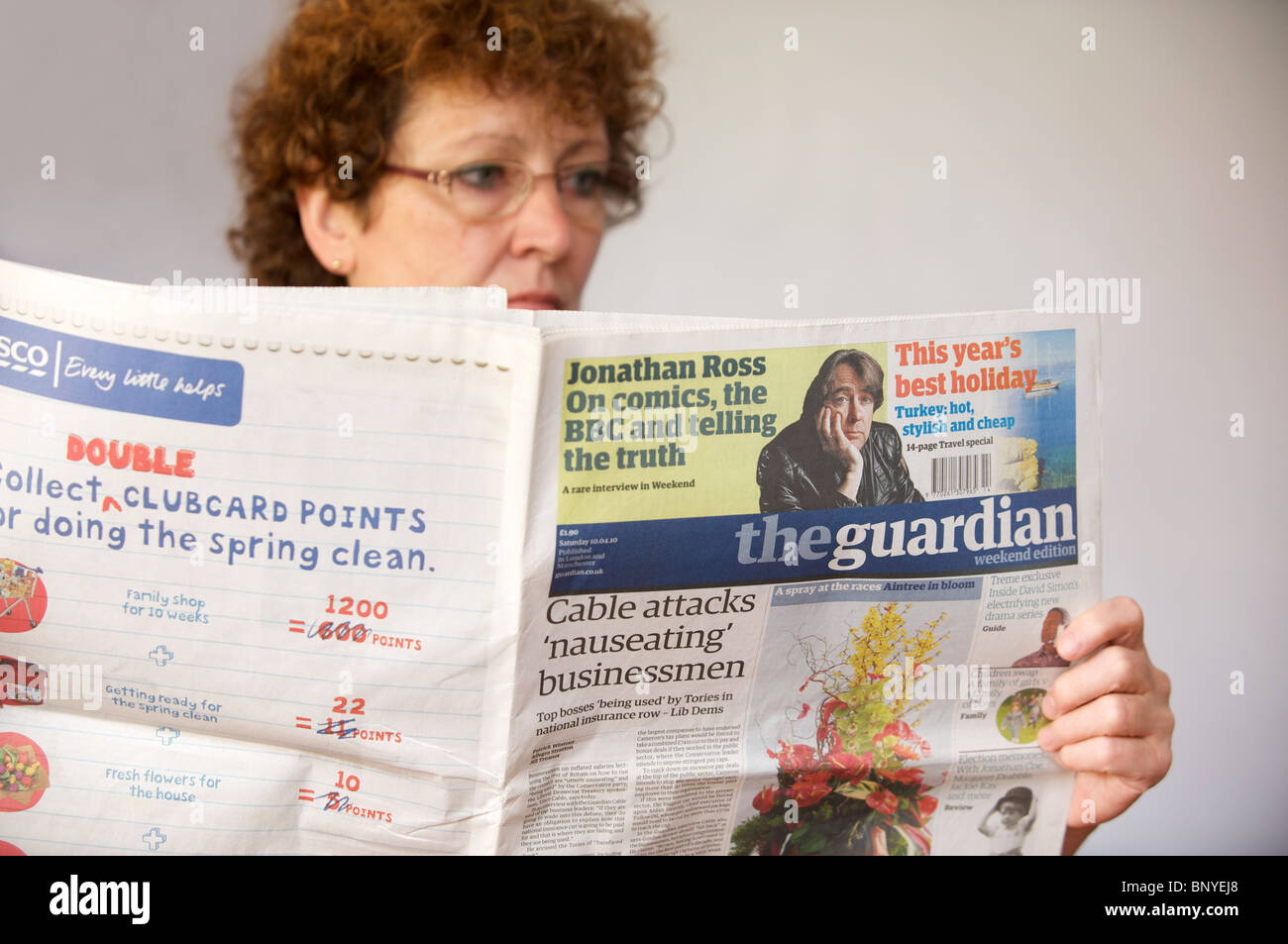 Donna leggendo una copia del quotidiano Guardian Foto Stock