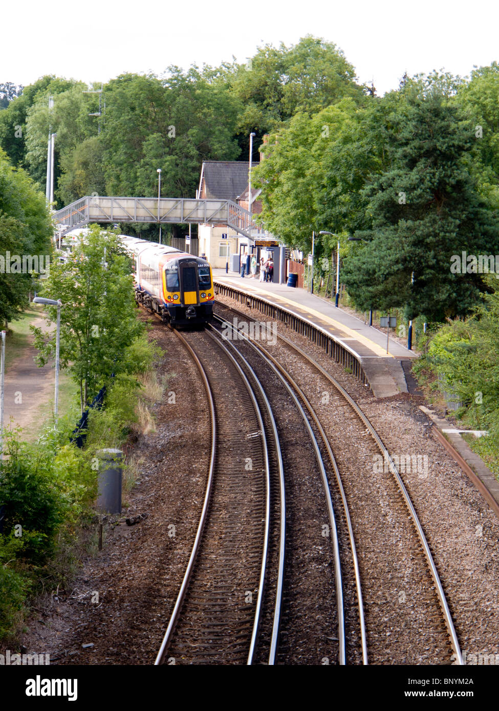 Un southwest trains treno a Waterloo passa attraverso la stazione di Ashurst nella nuova foresta, Hampshire Foto Stock