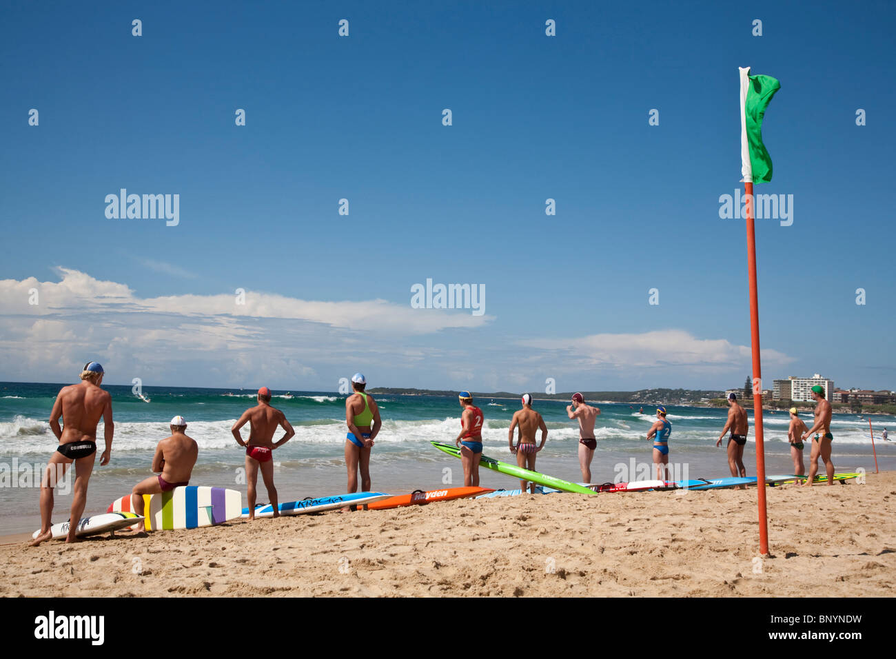 Surf Lifesavers aspettano l'inizio di una scheda per il salvataggio di gara. Cronulla Beach, Sydney, Nuovo Galles del Sud, Australia Foto Stock