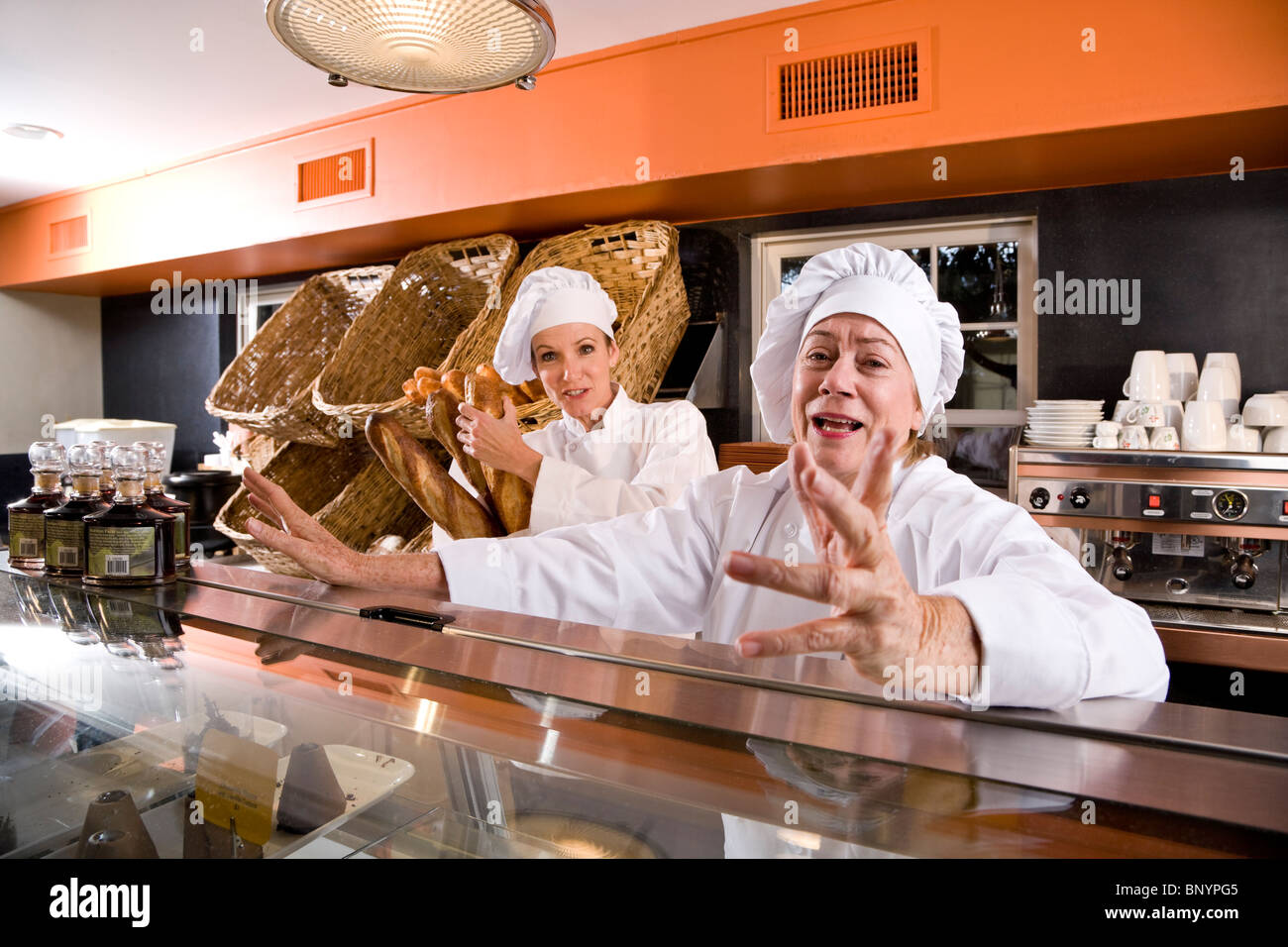Fornai lavorando dietro bakery shop counter Foto Stock Fornai lavorando dietro bakery shop counter Foto Stock