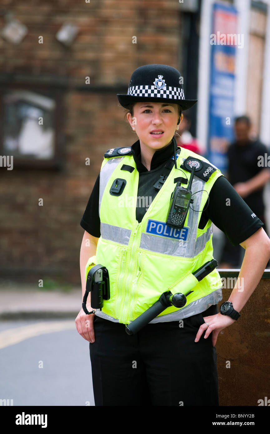 Donna di polizia in Ross on Wye la chiusura di una strada per il carnevale annuale. Donna funzionario di polizia, UK. Foto Stock
