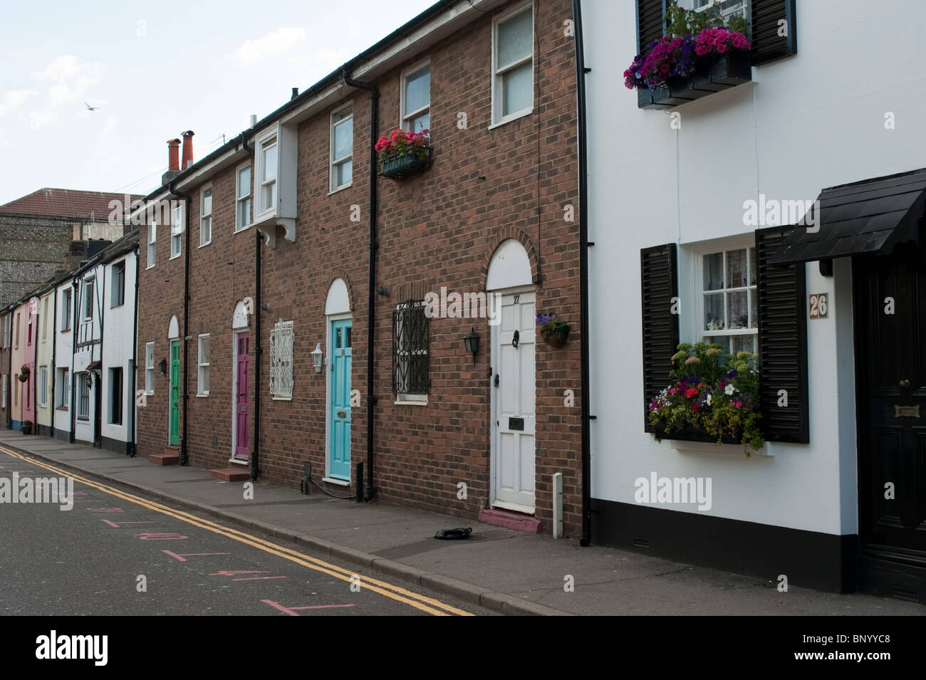 Fila di case con dipinto luminosamente porte, nella tomaia Gardner Street, Brighton, dove una strada del mercato si tiene ogni Sabato Foto Stock